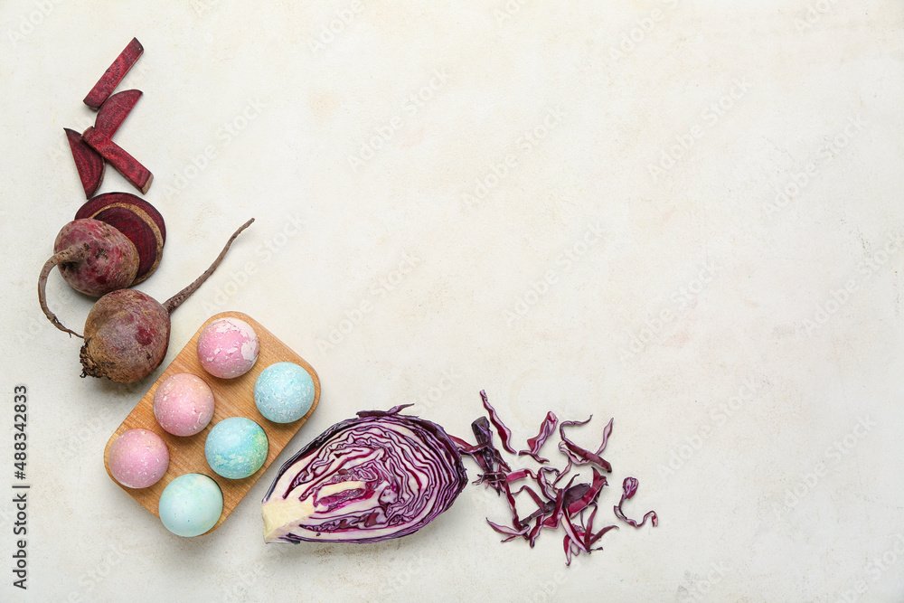 Holder with beautiful Easter eggs, purple cabbage and beet on light background