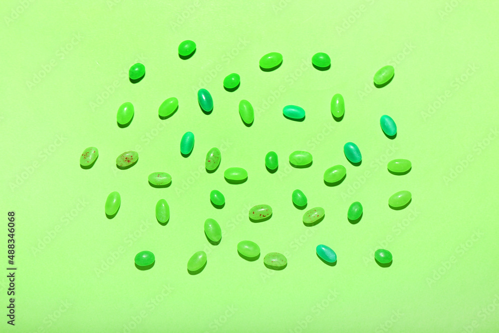 Different jelly beans on green background