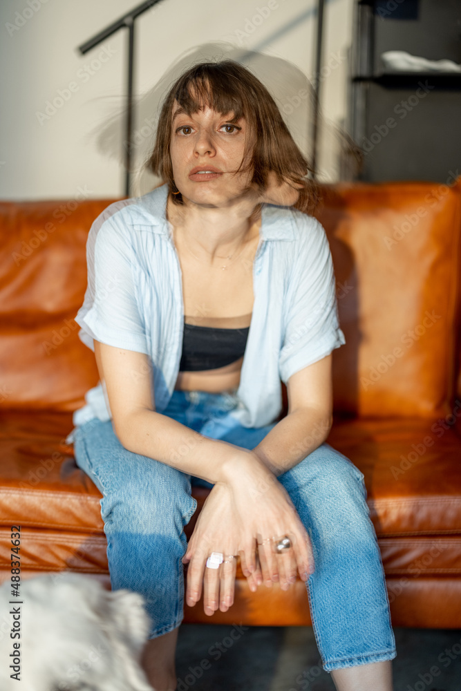 一位年轻自信的女性坐在家中沙发上的肖像。双曝光图像技术