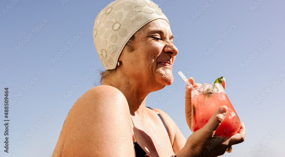 在夏天享受tiki鸡尾酒的成熟女性