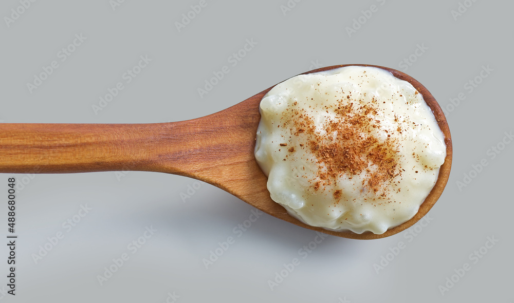 rice and milk pudding in wooden spoon