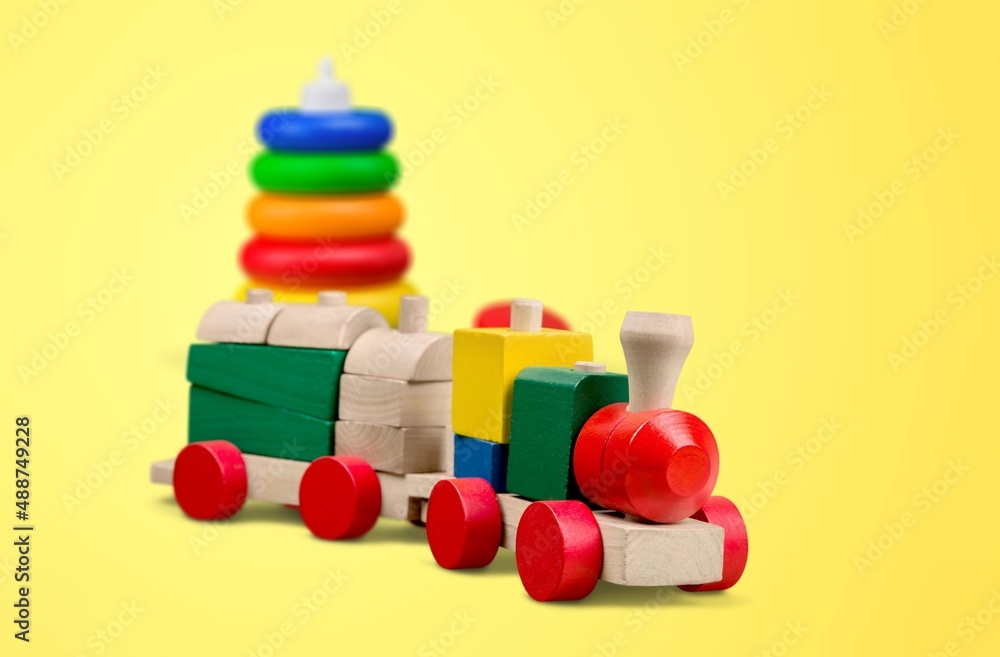 婴儿玩具背景。木制玩具火车、木制堆叠金字塔和彩色木砖