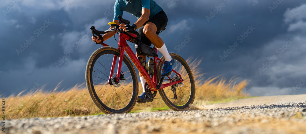 自行车运动员在恶劣天气下在碎石路上练习