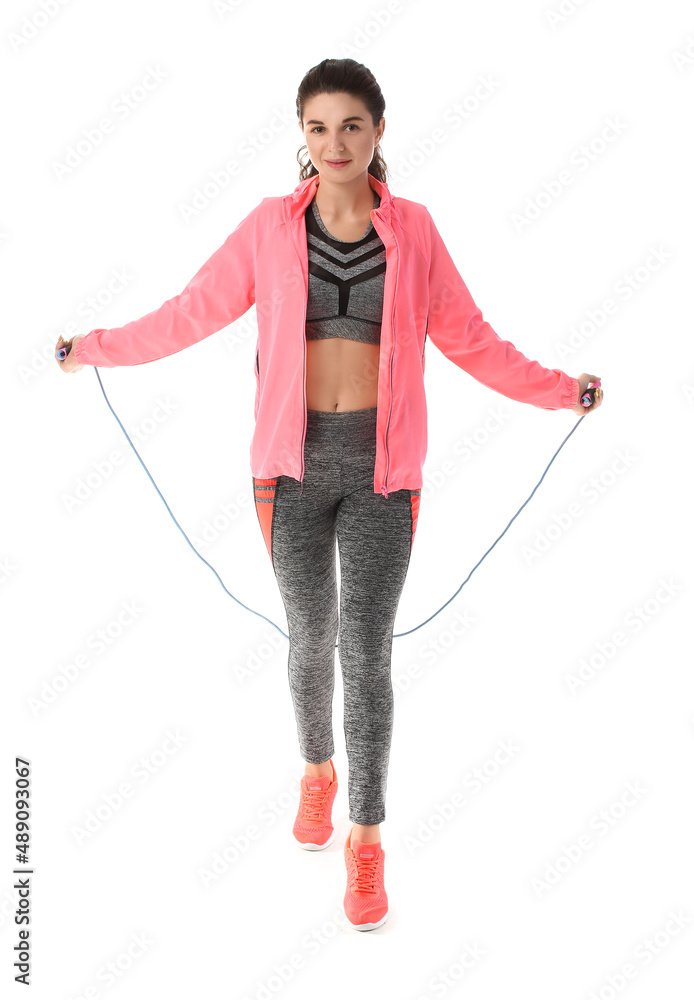 年轻的运动型女性在白底跳绳