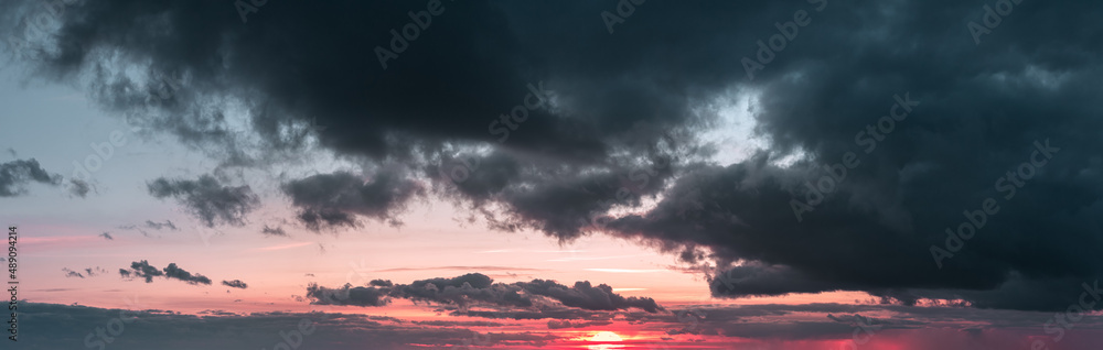 乌云密布、天空红润的日落全景图