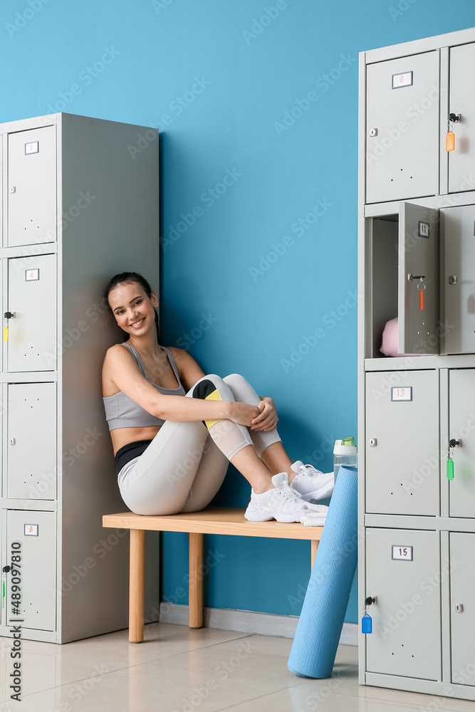 Sporty young woman in locker-room