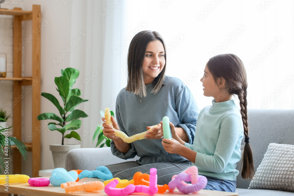 小女孩和她的妈妈在家玩Pop Tubes