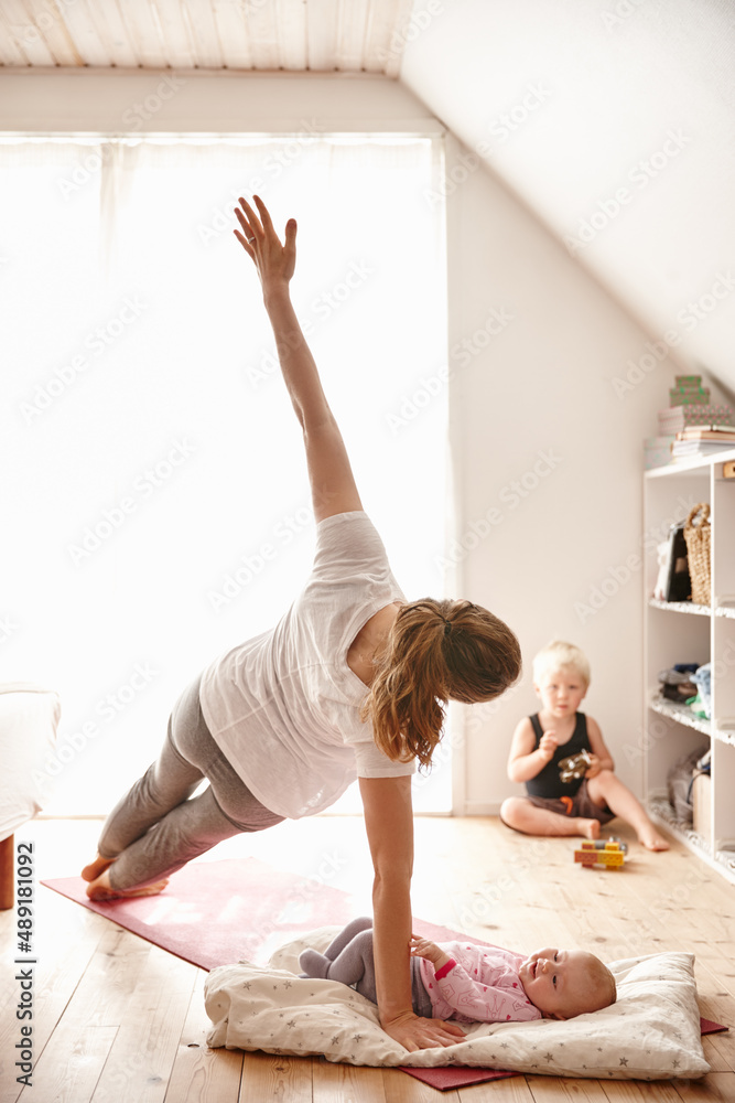 Mom sure likes yoga. Shot of an attractive young woman bonding with her children while doing yoga.