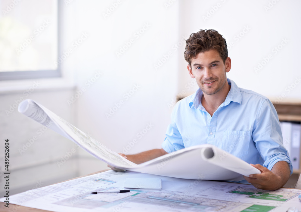 They are going to build my vision. Shot of an attractive male architect holding plans while sitting 