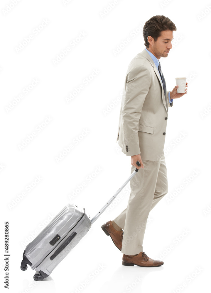 商业在移动。一位年轻商人带着行李箱和咖啡独自行走的工作室照片