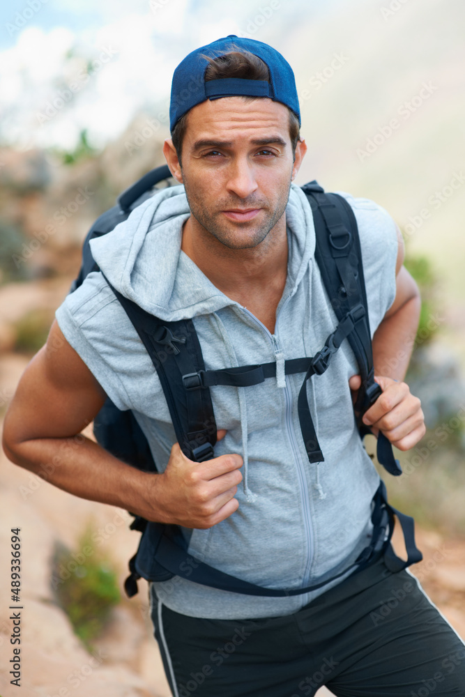 总是在寻找新的冒险……一个背着背包看着相机的年轻徒步旅行者。