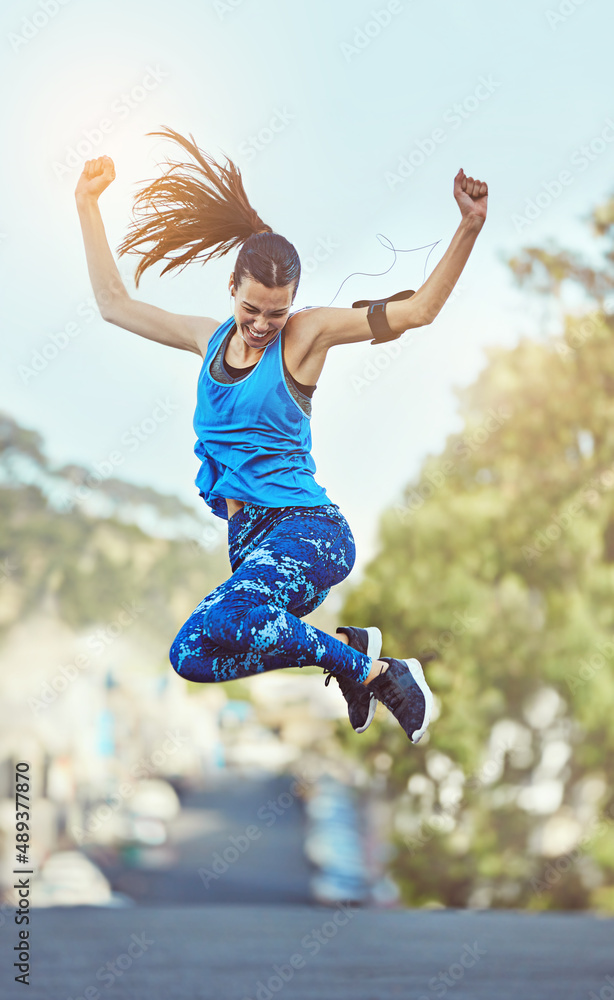 Hard work never goes unnoticed. Shot of a young woman jumping in mid air after her workout.