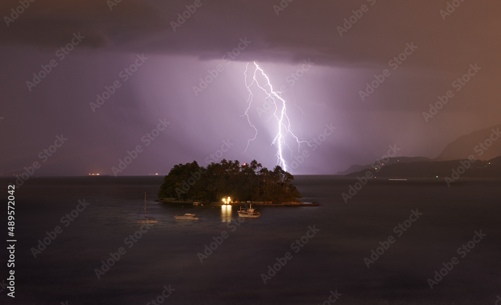 穆迪天气。夜间风暴中一道闪电击中一个小岛。