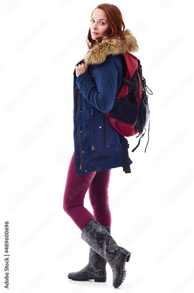 保暖时尚。一位年轻女性穿着冬装，背着背包的工作室肖像
