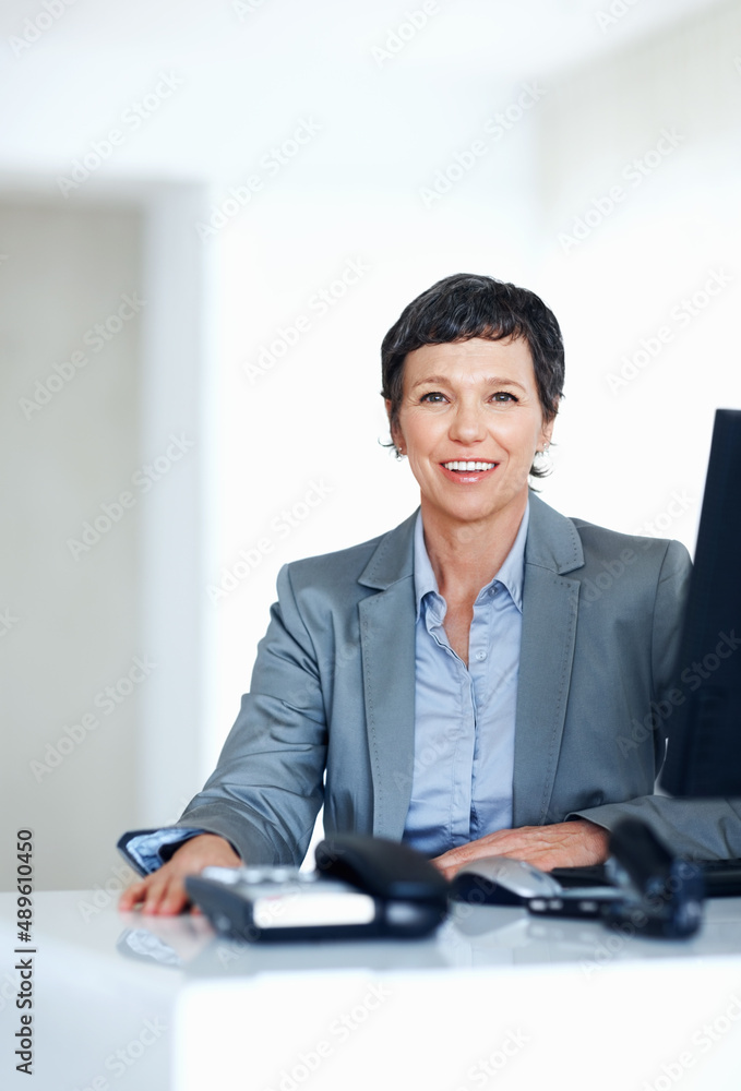 办公桌上的成熟商务女性。办公桌上微笑的成熟商务女人的画像。