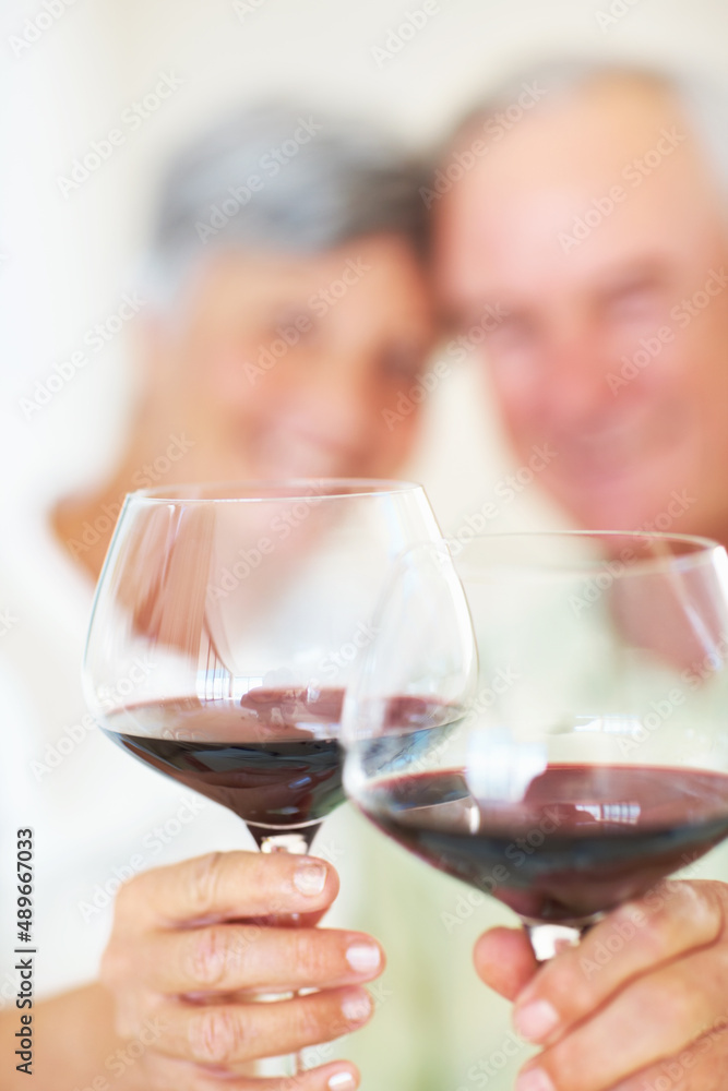 成熟的夫妇举杯庆祝红酒。成熟的夫妇用吐司庆祝的肖像，聚焦葡萄酒魅力