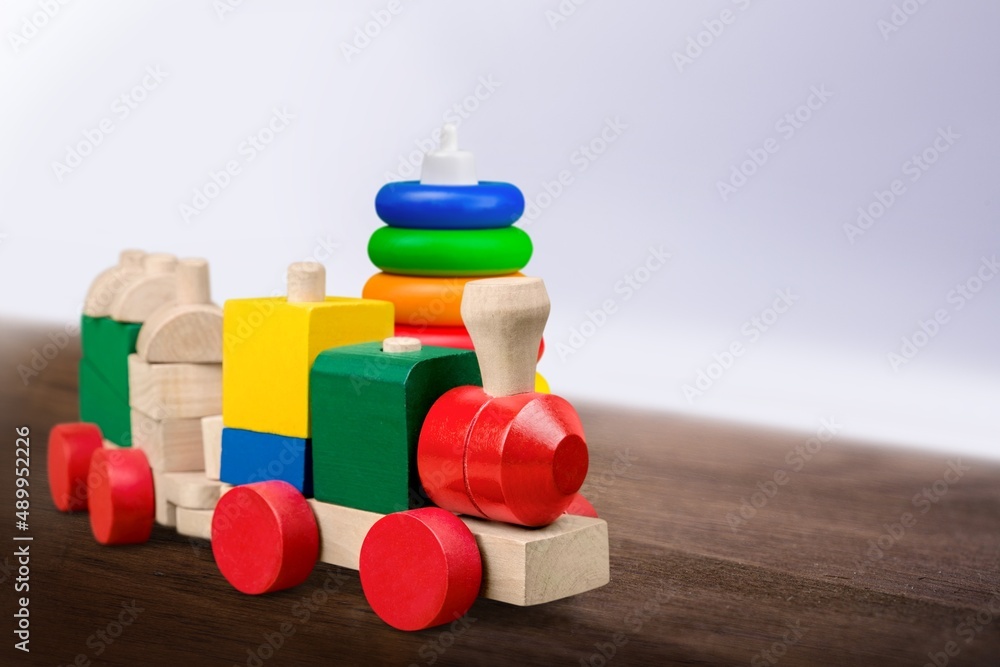 婴儿玩具背景。木制玩具火车、木制堆叠金字塔和彩色木砖