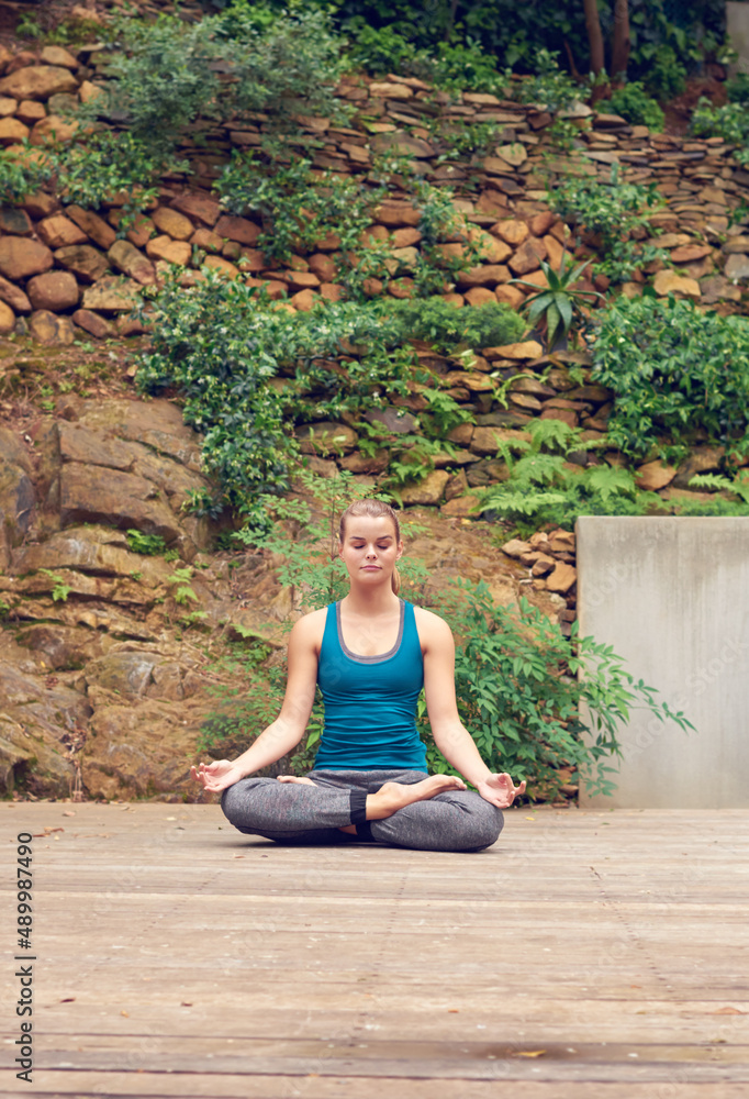 从内心寻找力量。一名年轻女子在户外练习瑜伽的照片。