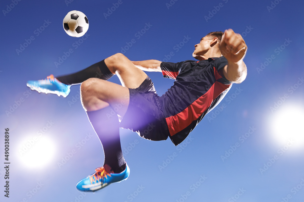 他赢得了比赛。一个年轻足球运动员在半空中踢球的镜头。