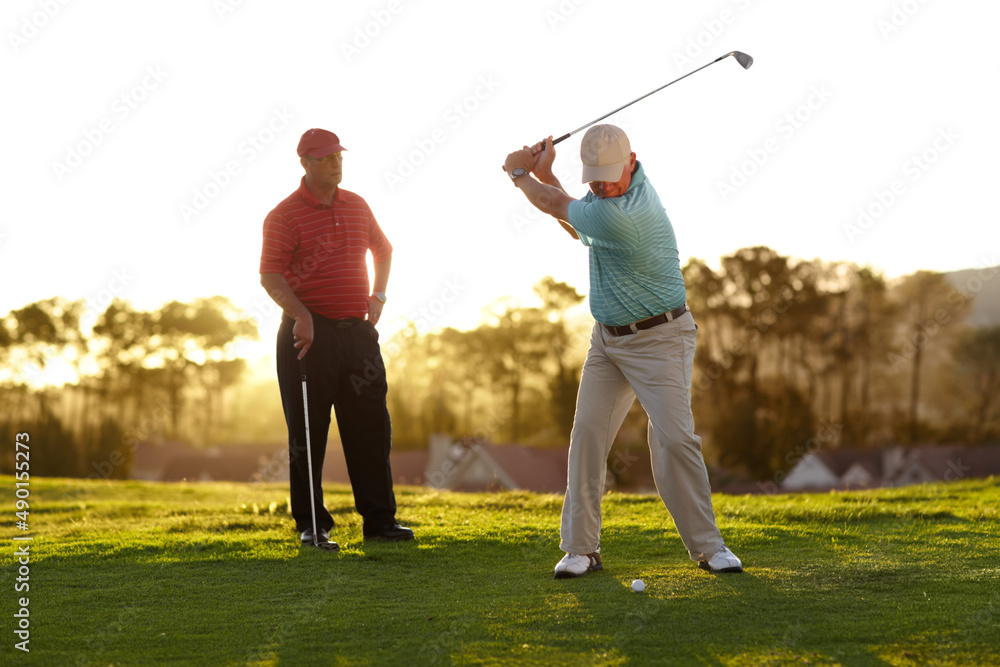 瞄准果岭。两名男性高尔夫球手正在进行一轮高尔夫比赛。