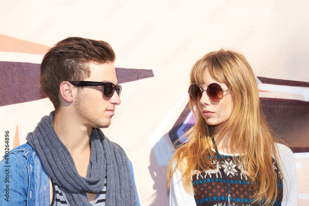 太阳照耀着我们247。一对年轻时尚的情侣戴着墨镜站在外面。