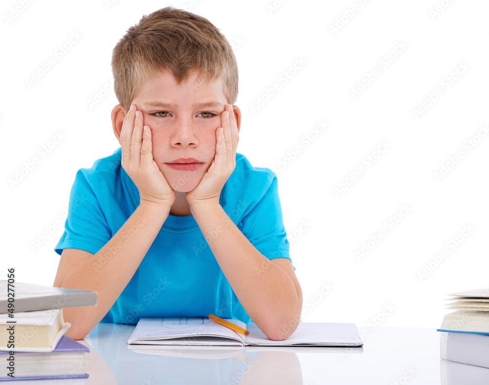 I like studying hard. Shot of bored boy sitting with his homework against a white background.