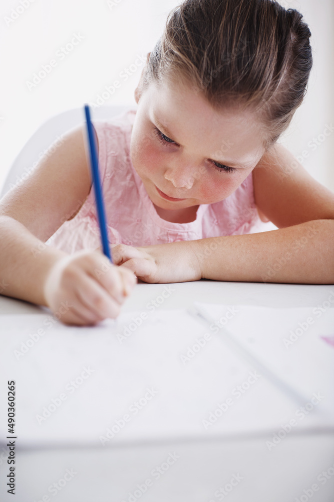 She always does her homework. Cropped shot of a little girl doing her homework.