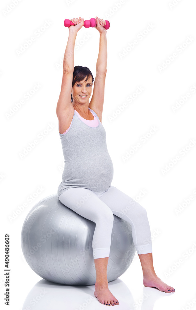 Keeping in shape, right down to her final trimester. A pregnant mother smiling with a pilates ball w