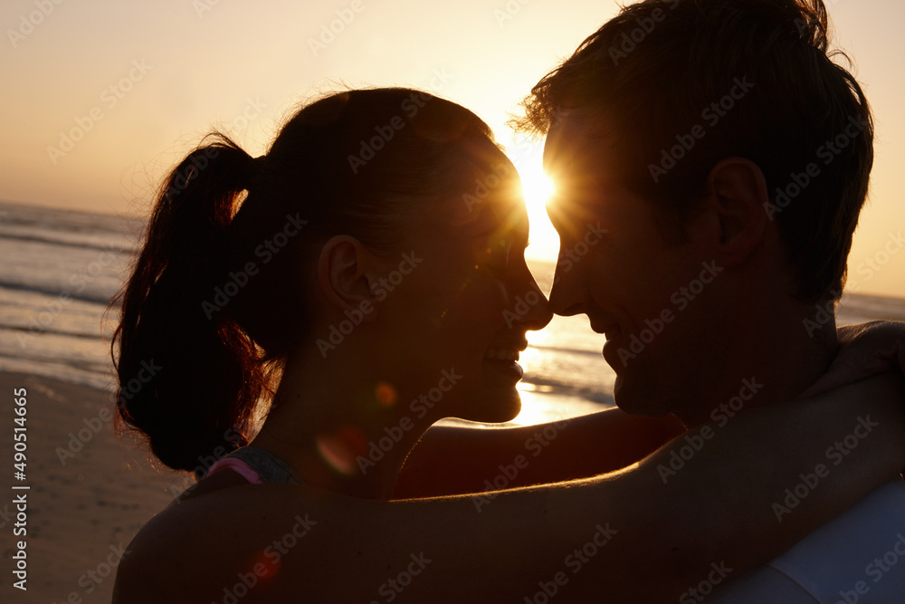 日落时分的真爱。日落时分一对情侣在海滩上浪漫的剪影。