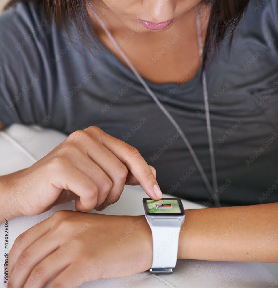 时间的技术。一个年轻女人看着她的智能手表的裁剪镜头。