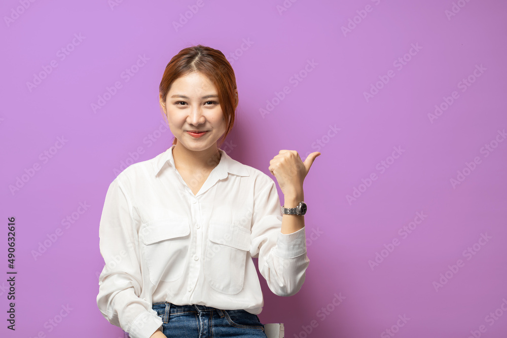 自信的年轻女子，带着自信的微笑，向左指着复制空间的标志，显示出良好的交易，建议