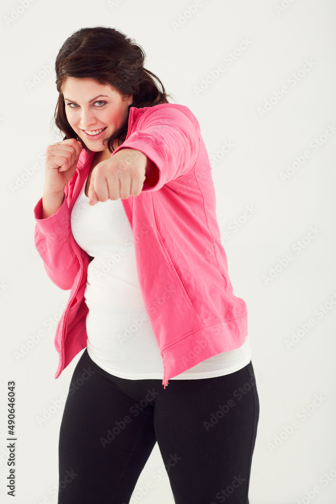 一次一磅。一名年轻女子穿着运动服挥拳的工作室镜头。