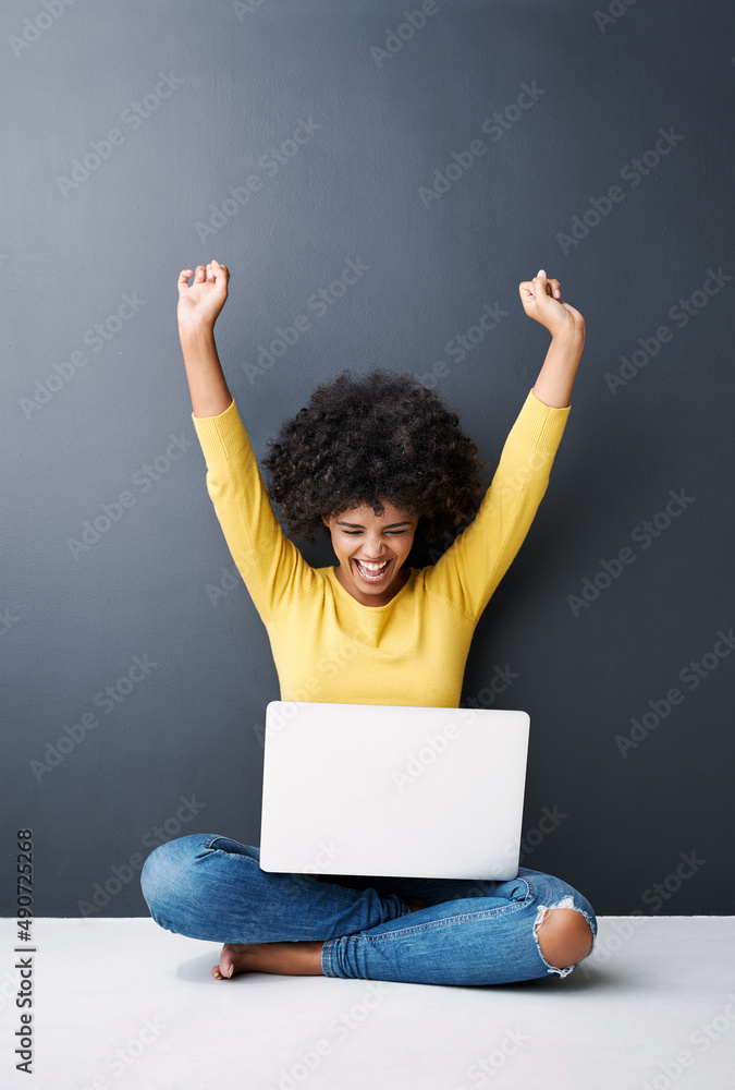 是的，我做到了。一个有魅力的年轻女子在用笔记本电脑对抗gre时欢呼的工作室镜头