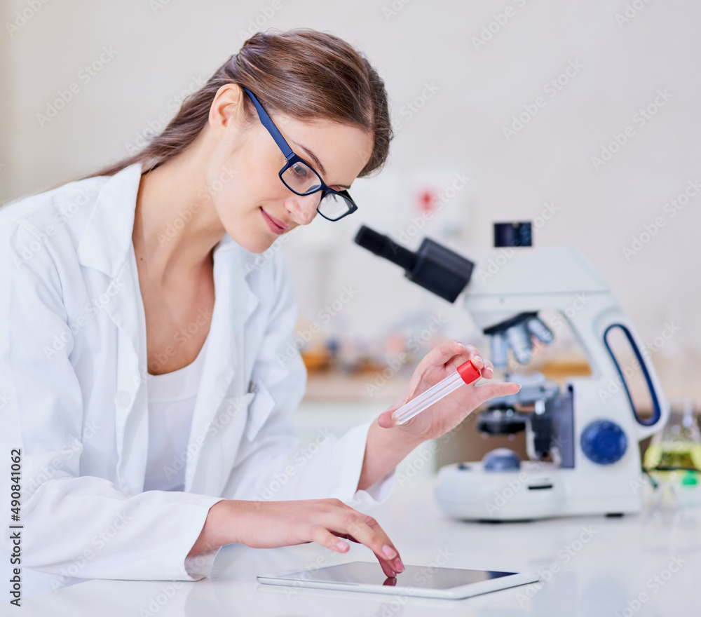 数字跟踪她的进展。一位科学家坐着用数字平板电脑和显微镜拍摄的照片