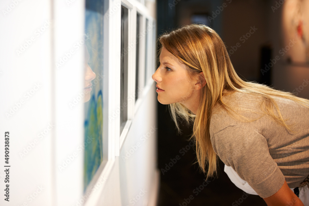 欣赏一个世纪的艺术。一个年轻女人在画廊里看画的镜头。