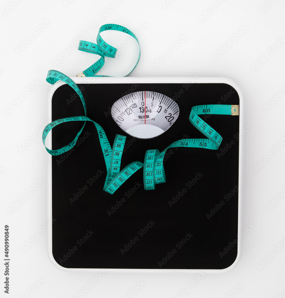 白色背景上的体重秤和卷尺，带复制空间，减肥或健康饮食续