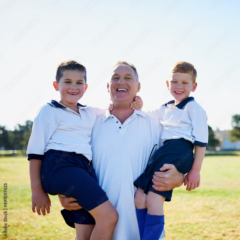他们对足球的热爱是家庭事务。一位自豪的父亲抱着两个儿子的画像