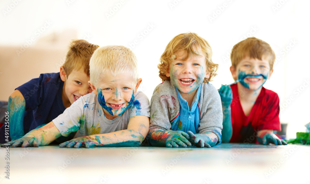 孩子就是孩子。四个可爱的小男孩的画像，上面涂满了油漆。