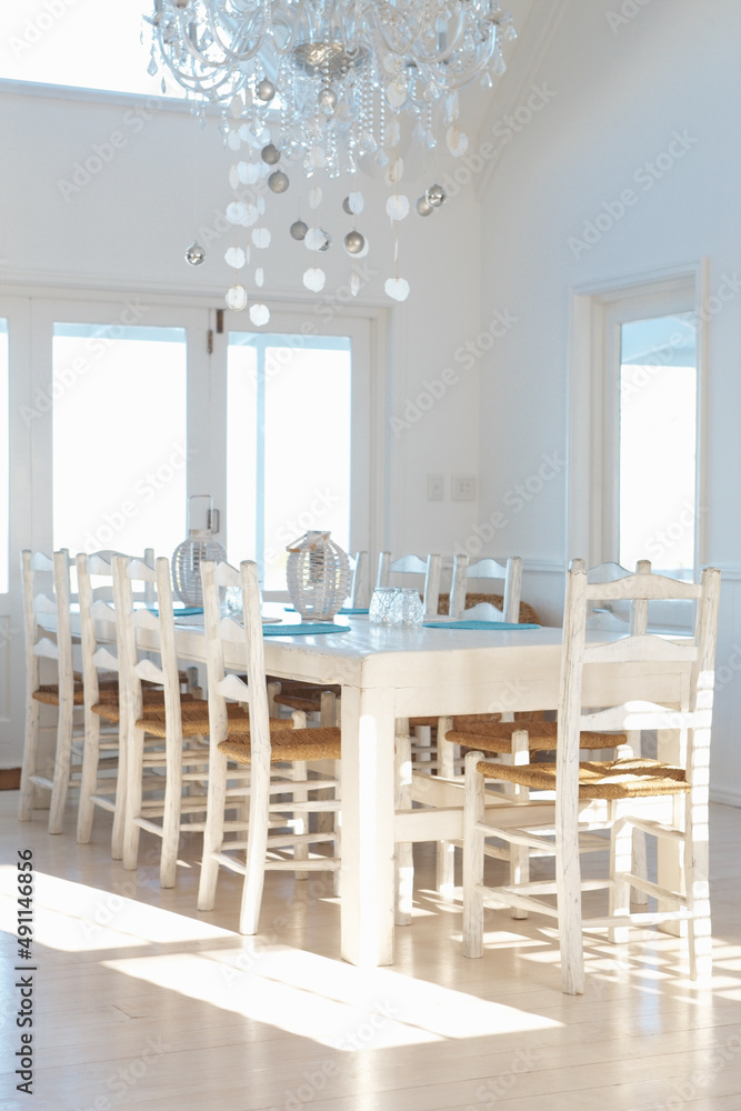 White interior with dining table and chairs and chandelier. Contemporary white interior with dining 