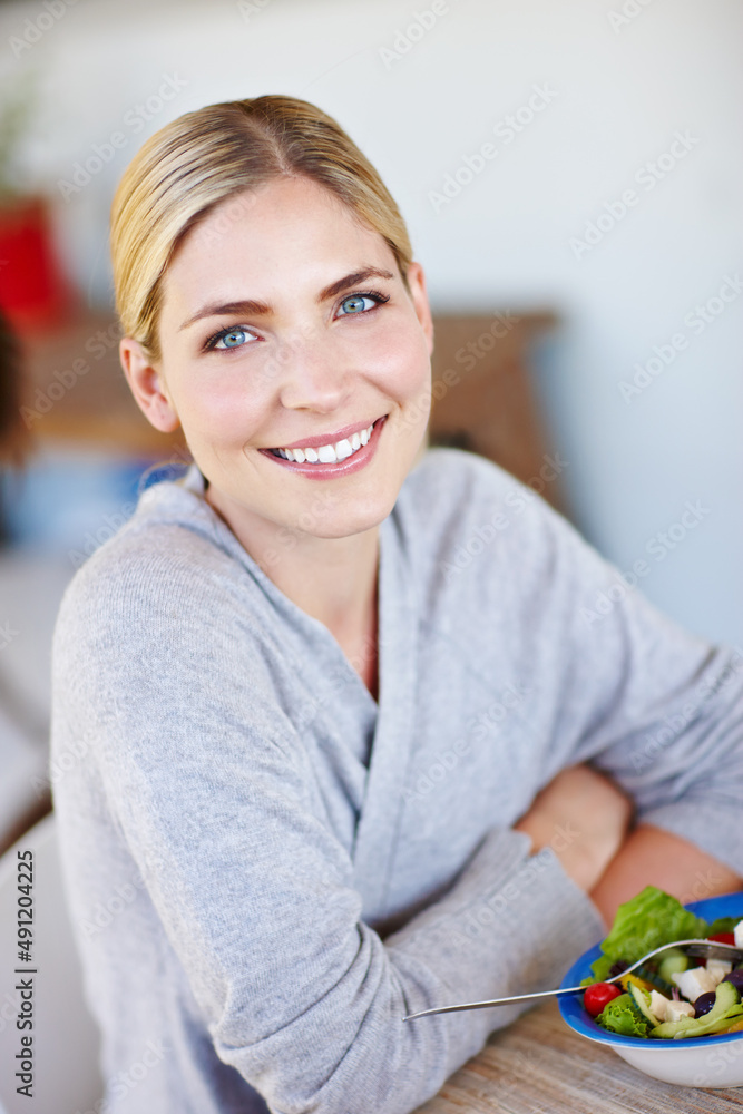 吃得干净，保持健康。一位美丽的年轻女性在家享用健康沙拉的照片。