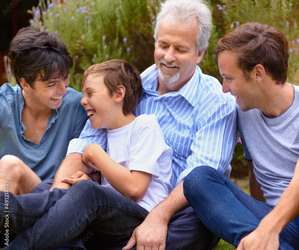 与我的孩子们建立联系。父亲和儿子们坐在草坪上互相大笑。