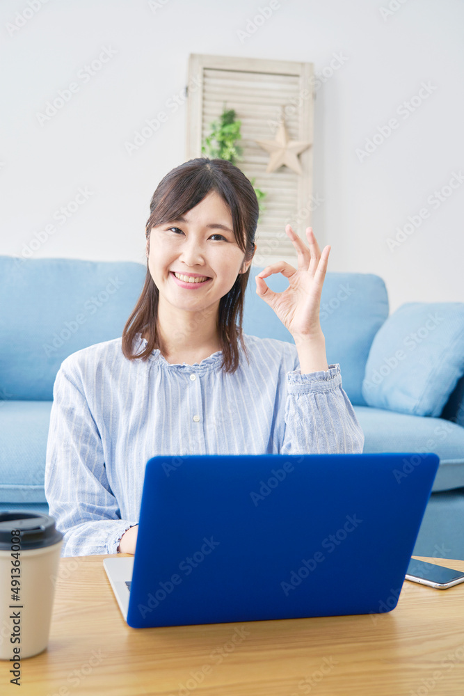 女性　パソコンを　OKサイン　リビング