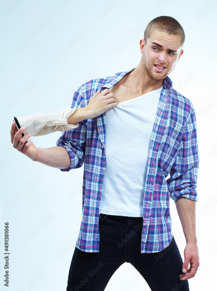 The pull of modern technology. A handsome young man having his shirt pulled by the hand coming out f