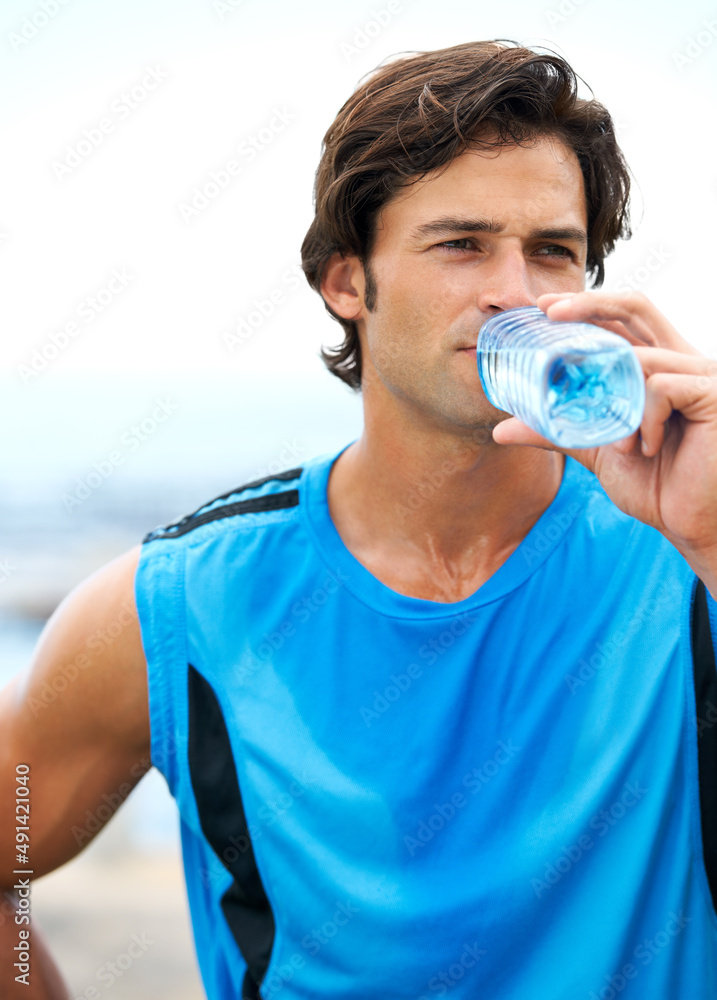 确保你在训练中喝足够的水。一个年轻健康的男人从饮水机器人里喝水