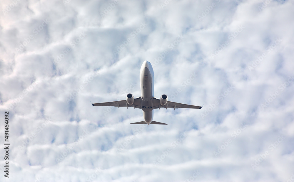 白色客机在天空中飞行，背景中的云彩令人惊叹-乘坐航空运输