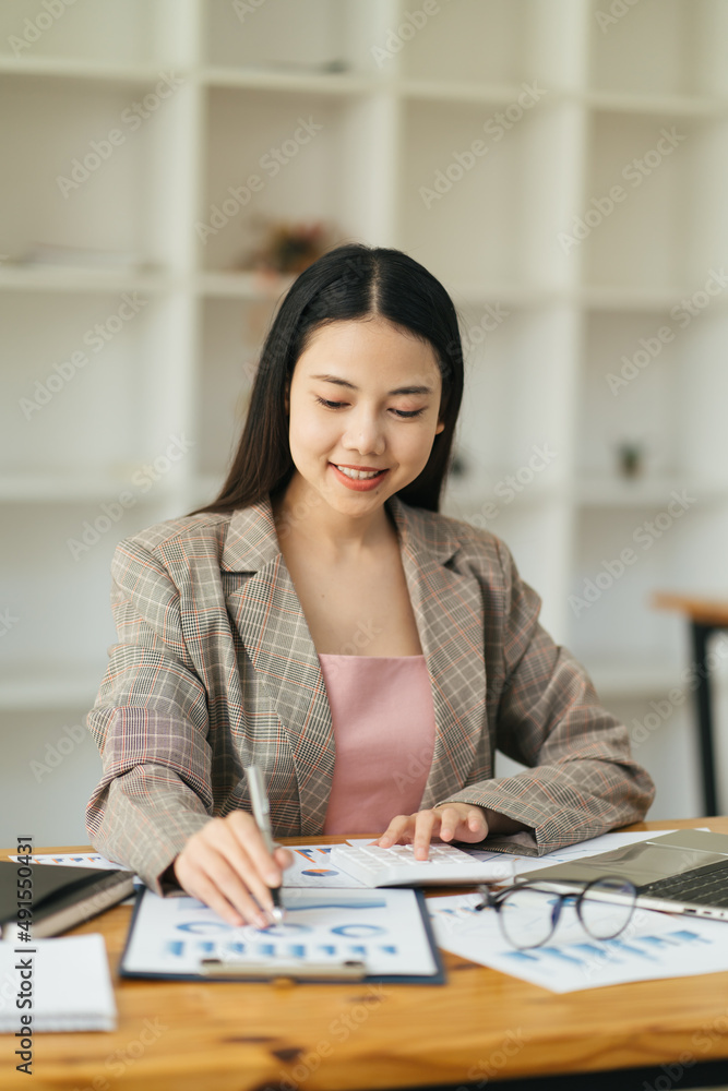商务女性在办公室的木桌子上用计算器做数学财务和商务工作ba
