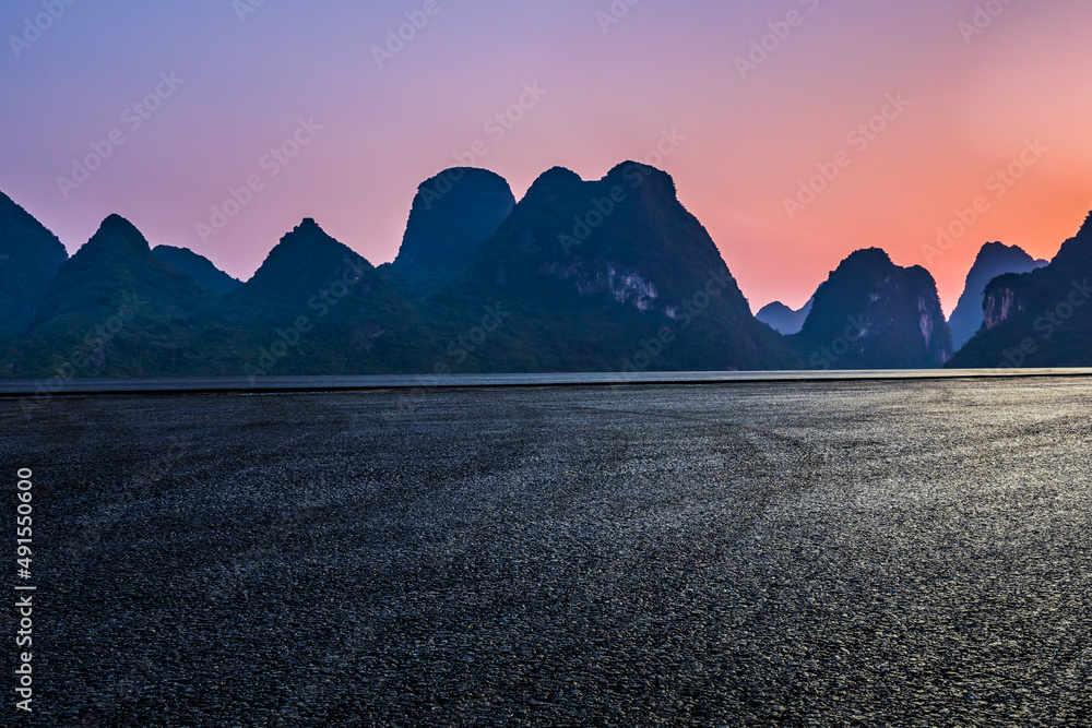 Asphalt road and mountain natural scenery at sunset. Road and mountain background.