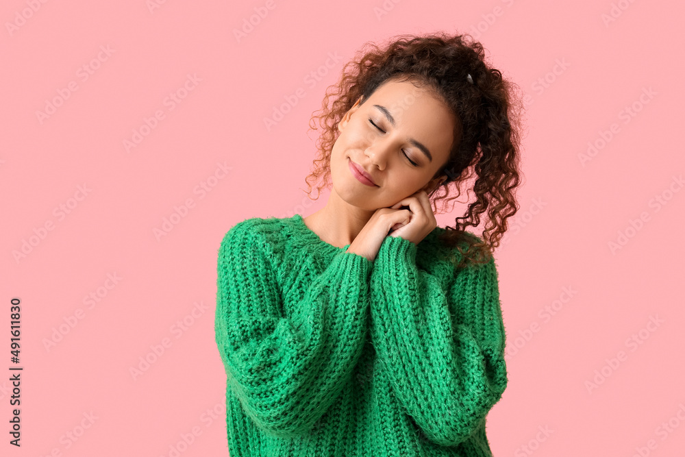 身穿粉色背景绿色毛衣的非洲裔美国年轻女性