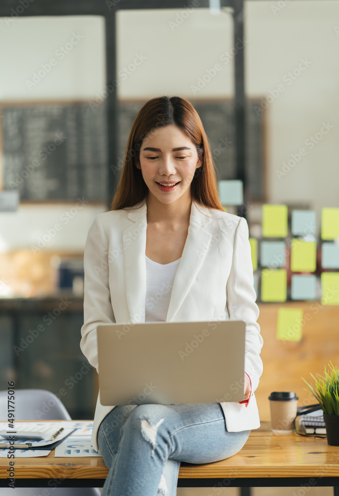 Pretty young business woman sitting on workplace, woman using laptop while sitting at her desk, busi