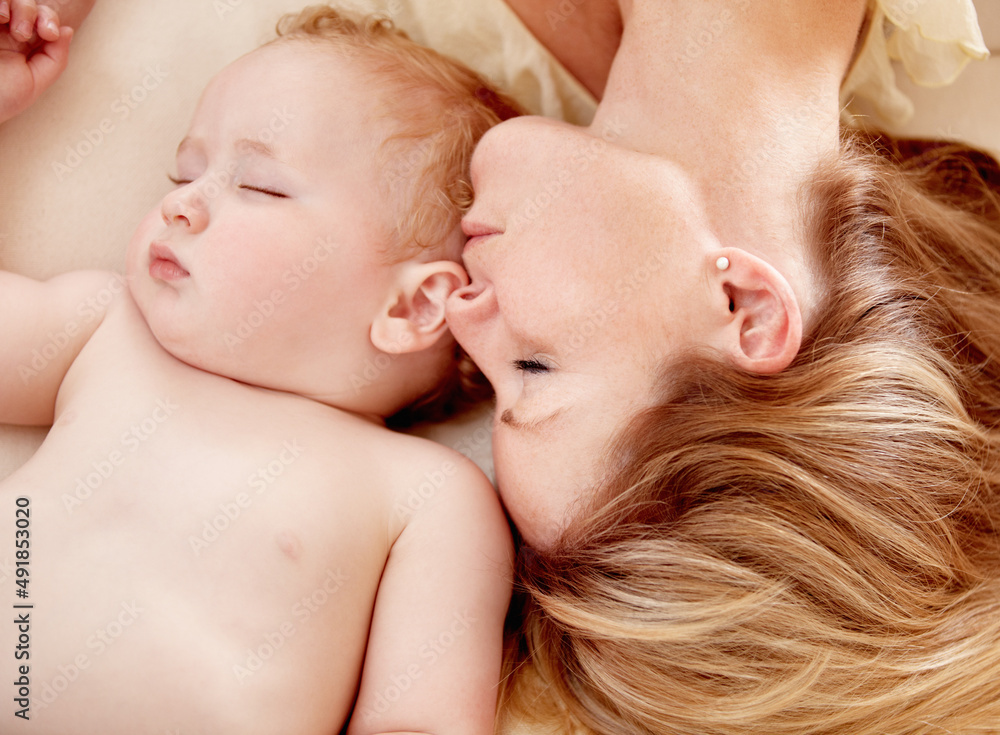 没有比母亲和孩子更亲密的纽带了。一个小男婴躺在母亲身边熟睡。
